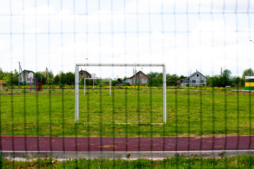 football field. green natural grass on the field. through the gate grid