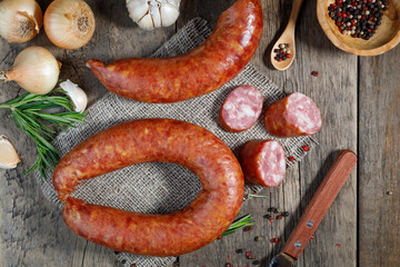 Smoked sausage with rosemary and spices on a wooden table. Top view. Flat lay.