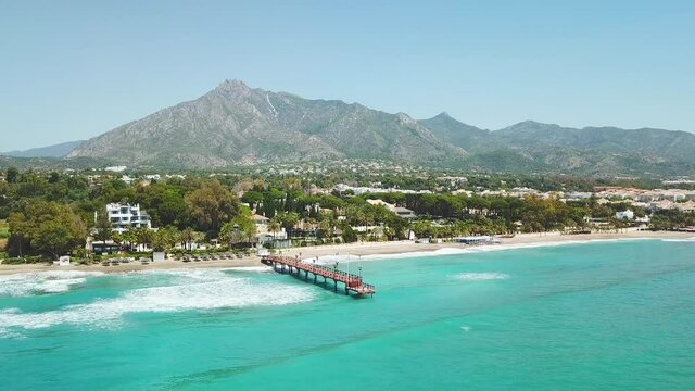 Beautiful and unique cinematic aerial view of luxury and exclusive area of Marbella, golden mile beach, Puente Romano Bridge.Luxury Clubs, Urbanisation in the most expensive area of Marbella. Forward