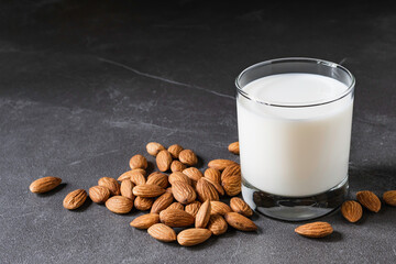 Close up glass of milk with almonds nut on table.