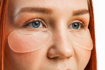 Fototapeta premium close beauty portrait of a red-haired girl with clean skin and patches under her eyes. Isolated on a white background.