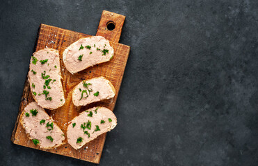 
Chicken pate on toast with fresh parsley on a cutting board on a stone background 
with copy space for your text