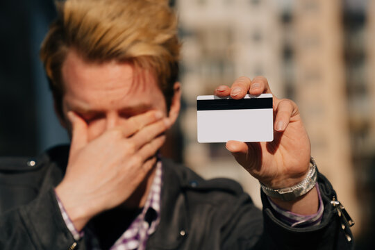 A Close-up Of A Young Man Cries, The Concept Of Credit Card Theft. Stole Cashless Money