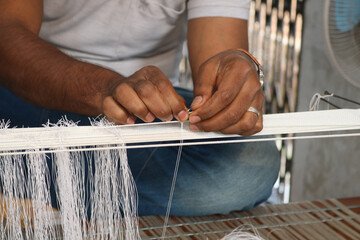 A Handloom Weaver preparing his loom in India.