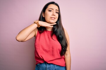 Young brunette woman wearing casual summer shirt over pink isolated background cutting throat with hand as knife, threaten aggression with furious violence