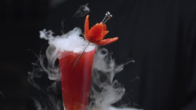 Close up ready-made Strawberry Rossini Cocktail with dry ice rotating and slowly moving on slider. Bar drinks series.