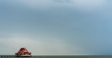 Red Thai style house in clear sky background : Phatthalung, THAILAND - July 8 , 2019 : King statue in beautiful sky at Lampam beach