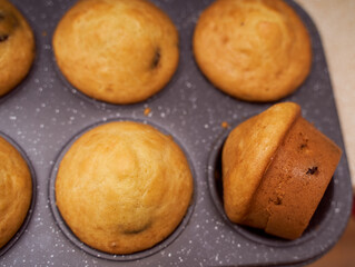 Homemade cupcakes with iron mold lie on a wooden plate