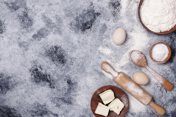 Eggs, flour and rolling pin on the table. Free space for text.