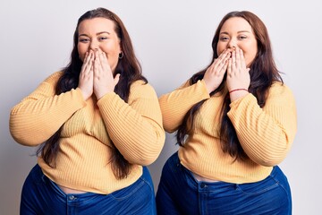 Young plus size twins wearing casual clothes laughing and embarrassed giggle covering mouth with...
