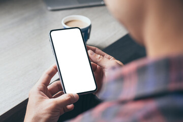 cell phone mockup image blank white screen.man hand holding texting using mobile on desk at coffee shop.background empty space for advertise.work people contact marketing business,technology