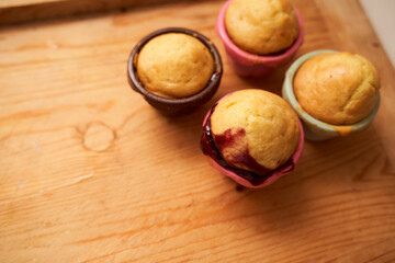 Homemade cupcakes lie on a wooden plate