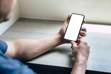 cell phone mockup image blank white screen.man hand holding texting using mobile on desk at coffee shop.background empty space for advertise.work people contact marketing business,technology