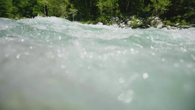 Super slow motion underwater river flow, clean pure water pouring over the stone, rapid in emerald river Soca, Slovenia