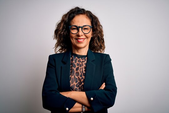 Middle age brunette business woman wearing glasses standing over isolated white background happy face smiling with crossed arms looking at the camera. Positive person.