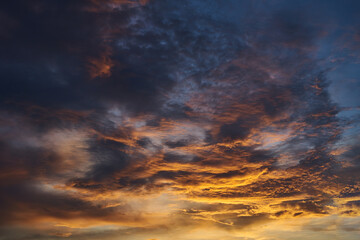 Naklejka na ściany i meble Background of vivid light of sunset with the dark cloud