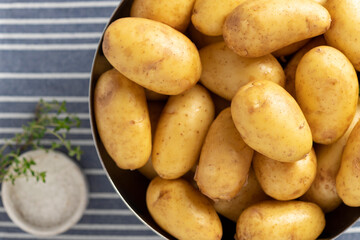 close-up of uncooked potatoes, thyme and salt. ingredients for cooking. view from above. horizontal image