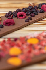 different kinds of chocolate with dried fruits on a wooden board