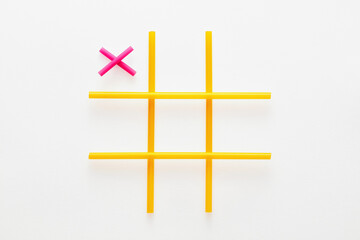 Tic tac toe game made of colorful straws on white background