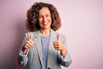 Middle age beautiful businesswoman wearing elegant jacket over isolated pink background success...