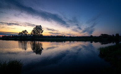 dawn on the Ural lake with trees on the shore in June, Russia, Ural