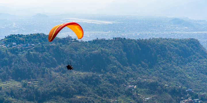 Paragliding in Nepal. Paraglider on the background Pokhara city and surrounding villages. Stock photo.