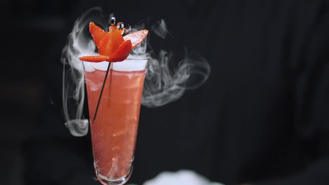 Close up ready-made Strawberry Rossini Cocktail with dry ice rotating and slowly moving on slider. Bar drinks series.