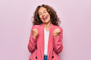 Middle age beautiful businesswoman wearing jacket standing over isolated pink background...