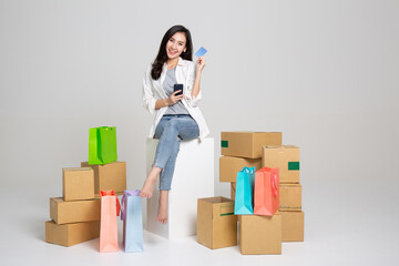 oung woman received online shopping parcel opening boxes and buying fashion items by using credit card