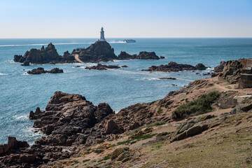 Fototapeta na wymiar High tide covers the causeway leading to La Corbiere lighthouse, Jersey, Channel Islands, UK