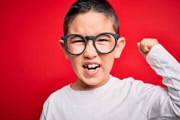 Young little smart boy kid wearing nerd glasses over red isolated background annoyed and frustrated...