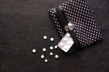 top view of white medicine and blister pack on black background 