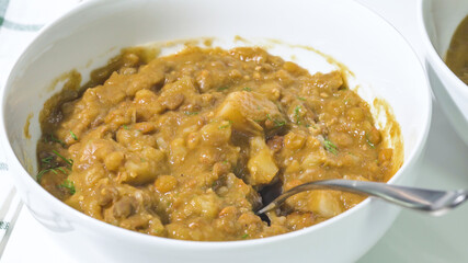 Creamy lentil soup in a bowl close up on kitchen table