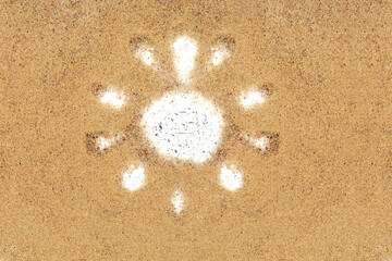 Drawing of the sun in the sand of a beach, summer background with copy space. Top view