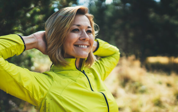 Closeup fun girl exercising outdoors in sun summer day, smile fitness woman stretching exercises training outside in park. Happy sportswoman isolaition in nature