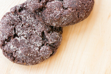 Top close up view of chocolate cookies on wooden table.Freshly baked choco biscuites.