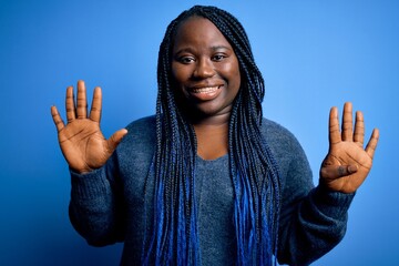 African american plus size woman with braids wearing casual sweater over blue background showing and pointing up with fingers number nine while smiling confident and happy.