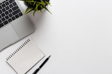 Top view office desk with notebook computer and office supplies on white background