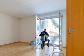 young male professional cleaner vacuuming dirty window blinds