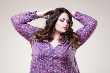 Plus size fashion model with professional makeup and hairstyle, fat woman on beige background
