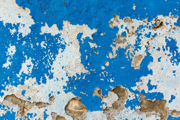 Wall with peeling blue paint with cracks