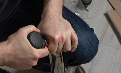 man assembling  office chair indoors. Assembly concept and purchase of furniture