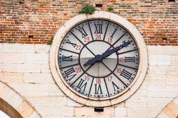Old clock of the medieval Porta Nuova, gate to the old town of Verona in Italy