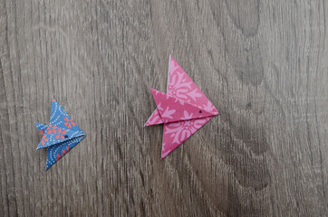 two colorful origami fishes on wooden