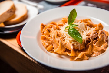 Fettuccine alfredo pasta with mushrooms, parmesan cheese and parsley leaf on a plate.
