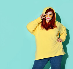 Trendy concentrated young fatty lady in casual clothing resettling spectacles on her nose. Three...