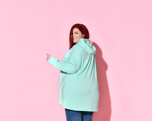 Adorable overweight lady turning sideways to camera holding hand on waist. Three quarter length...