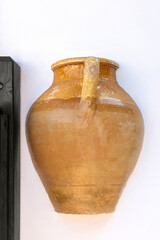 Exterior wall decoration of a greek house.Clay jug in a white wall of a house. Fancy exterior wall decoration at home. Mediterranean style. Coastal design. Corfu island, Greece.