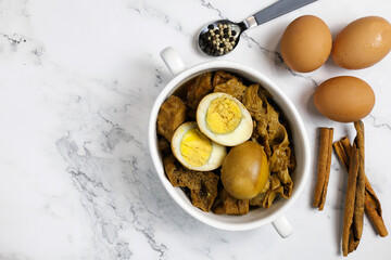 Half Stewed Egg and tofu with ingredients on white table