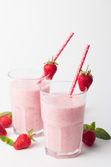 A glass of fresh strawberry smoothie on a white background. Summer drink shake, milkshake and refreshment organic concept.